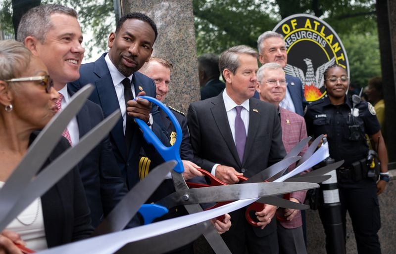 Atlanta Mayor Andre Dickens, center, and Gov. Brian Kemp joined together in helping to open a new police precinct at a ribbon-cutting ceremony in Buckhead. Ben Gray for The Atlanta Journal-Constitution
