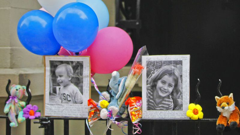 In this Oct. 27, 2012, file photo, photographs of 6-year-old Lulu Krim and her 2-year-old brother, Leo, are displayed alongside balloons and stuffed animals at a memorial outside the apartment building where they lived in Manhattan. Opening arguments began Thursday, March 1, 2018, for Yoselyn Ortega, the nanny charged with murder in the Oct. 25, 2012, stabbing deaths of the children.