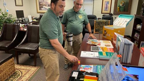 Grayson Elementary School teacher Matt Schoen and Principal Chris Brown look over classroom materials that will be used to help teach reading. Grayson is part of a pilot program in Gwinnett County Public Schools to revamp the district's approach to literacy. (Josh Reyes / Josh.Reyes@ajc.com)