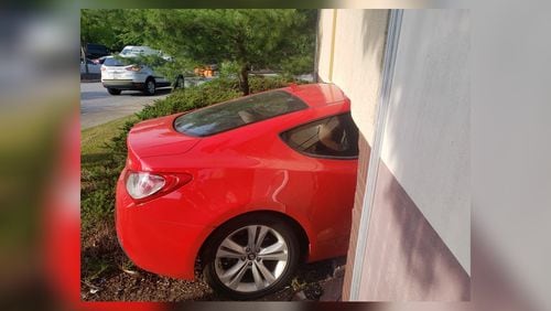 A red sedan reportedly jumped a curb and ran into a veneer wall near a service door and storage area at the corner of one building, according to Gwinnett County fire officials.