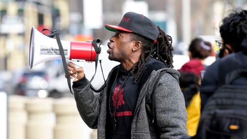 Gazi Kodzo, leader of the Black Hammer organization, leads protestors in chants against CNN Thursday, Jan. 6, 2022 in front of the CNN building in Atlanta. Daniel Varnado/For the Atlanta Journal-Constitution)