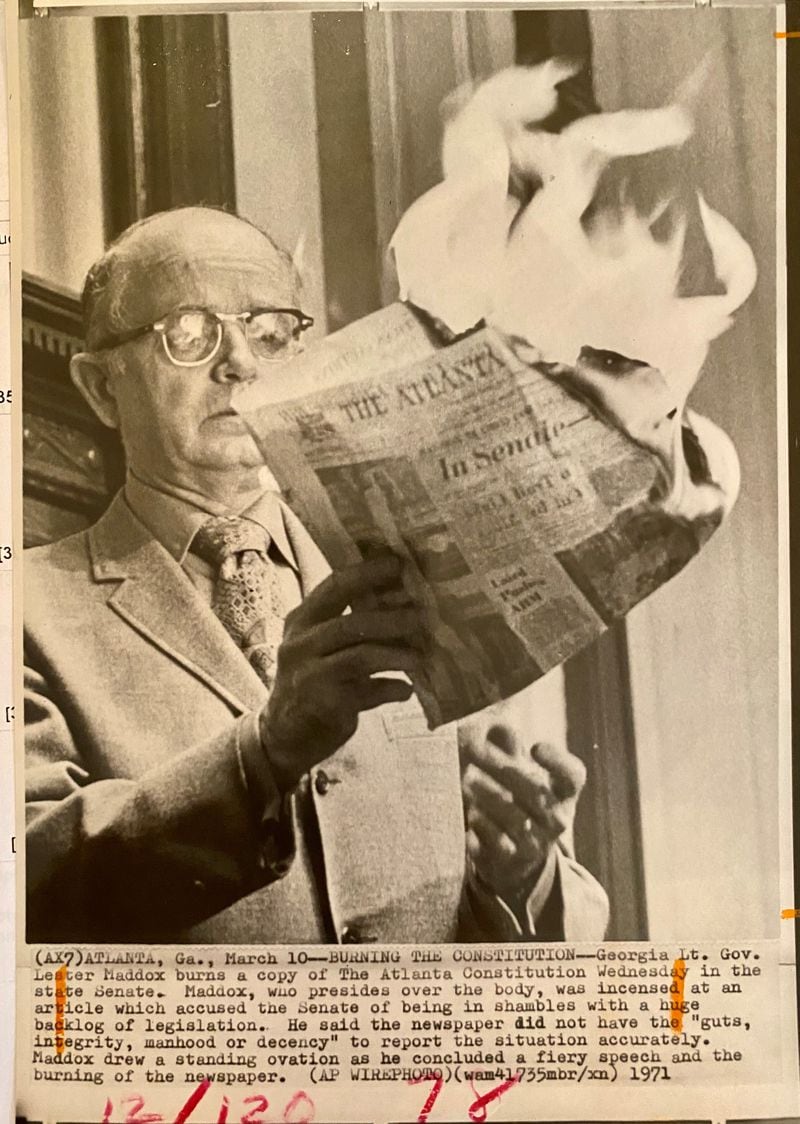 The Georgia Historical Society was kind enough to send this recently discovered 1971 photograph of Lt. Gov. Lester Maddox In the state Senate chamber, burning a copy of The Atlanta Constitution, the newspaper he loved to hate. The caption declares that Maddox, who had previously served as the state’s governor, “was incensed at an article which accused the Senate of being in shambles with a huge backlog of legislation. He said the newspaper did not have the ‘guts, integrity, manhood or decency’ to report the situation accurately.”