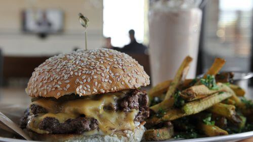 Bocado’s Burger Stack includes American cheese, pickle and, mayo, served here with herb fries and a chocolate shake.