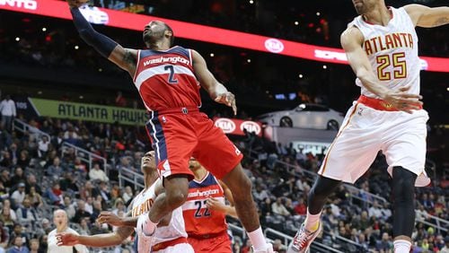032116 Atlanta: Wizards John Wall lays it up for two past Hawks Jeff Teague and Thabo Sefolosha in a basketball game on Monday, March 21, 2016, in Atlanta. The Wizards beat the Hawks 117-102. Curtis Compton / ccompton@ajc.com