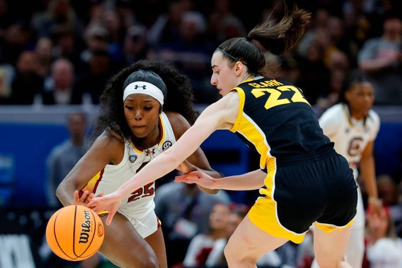 South Carolina's Raven Johnson (left) swipes the ball from Iowa's Caitlin Clark during Sunday's game.
