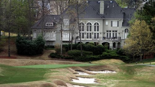 A huge home sits next to a green on the golf course at the Country Club of the South in Johns Creek. AJC FILE PHOTO