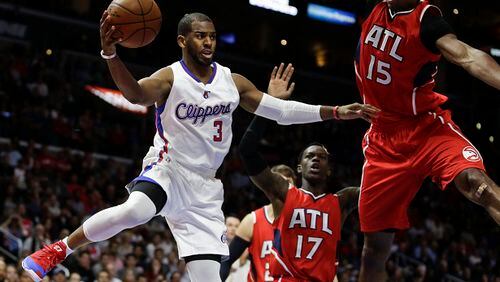 Los Angeles Clippers guard Chris Paul, left, passes around Atlanta Hawks center Al Horford during the second half of an NBA basketball game in Los Angeles, Monday, Jan. 5, 2015. The Hawks won 107-98. (AP Photo/Chris Carlson) The famous Chris Paul is outnumbered by Hawks. (Chris Carlson/AP photo)