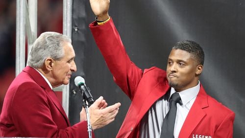 Team owner Arthur Blank applaudes former Falcons running back Warrick Dunn as he is inducted into the Ring of Honor during half time against the Saints in a NFL football game on Thursday, December 7, 2017, in Atlanta.  Curtis Compton/ccompton@ajc.com