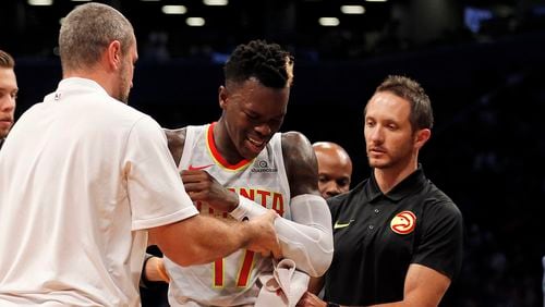 Atlanta Hawks' Dennis Schroder is helped off the court after suffering an injuring against the Brooklyn Nets during the fourth quarter of an NBA basketball game, Sunday, Oct. 22, 2017, in New York. The Nets won 116-104. (AP Photo/Adam Hunger)