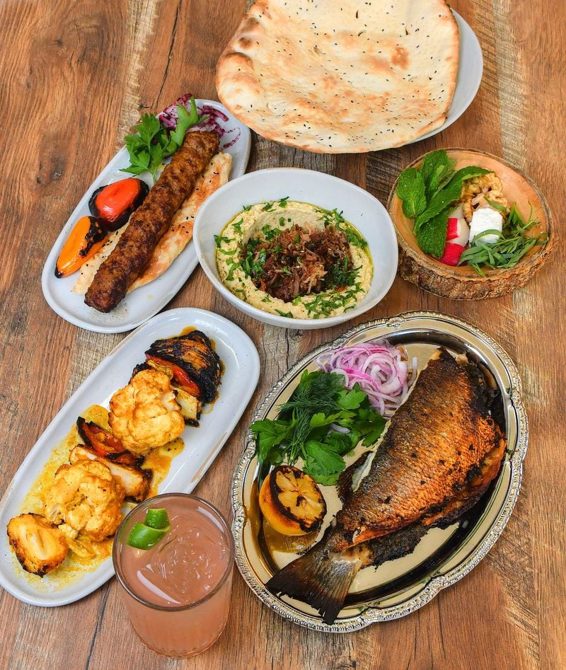 Delbar offers Persian delights, including, clockwise from top: herb cheese and bread, stuffed trout, hummus with lamb and za'taar (center), koobideh and grilled veggies. Chris Hunt for The Atlanta Journal-Constitution