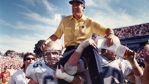 Yellow Jackets coach Bobby Ross is carried off the field after a big victory in 1990. Todd Stansbury, then the team's academic advisor and now the Tech athletic director, is in the background in the white shirt and sunglasses. AJC file photo