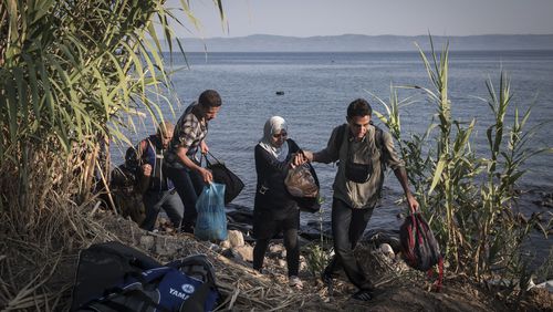 Syrian migrants walk from their landing site toward police authorities after arriving in Lesbos, Greece. Sergey Ponomarev/The New York Times file