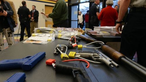 Guns with safety locks are on display at Marietta Police Department's gun safety course, Thursday Jan. 24, 2013.