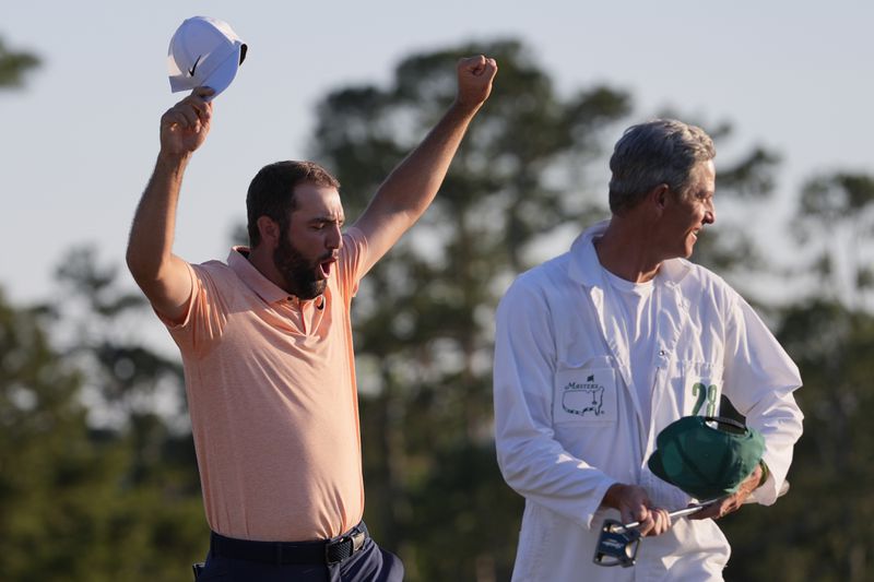 Scottie Scheffler celebrates with his caddie Ted Scott after winning the Masters golf tournament at Augusta National Golf Club Sunday, April 14, 2024, in Augusta, Ga. (AP Photo/David J. Phillip)