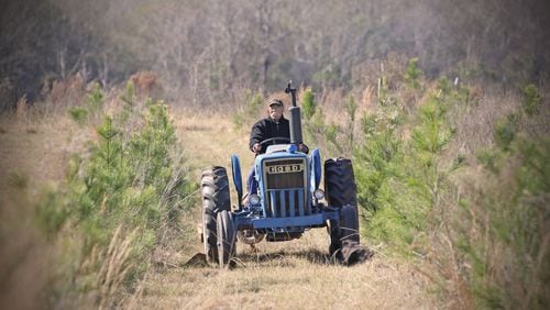 Cleveland Whitehead works on his tractor on his Flint River Farms property near Montezuma. 
Courtesy of Eric Dusenbery