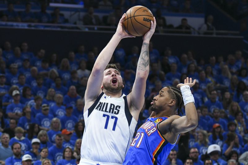 Dallas Mavericks guard Luka Doncic (77) goes up for a shot against Oklahoma City Thunder guard Aaron Wiggins (21) during the first half in Game 2 of an NBA basketball second-round playoff series, Thursday, May 9, 2024, in Oklahoma City. (AP Photo/Kyle Phillips)