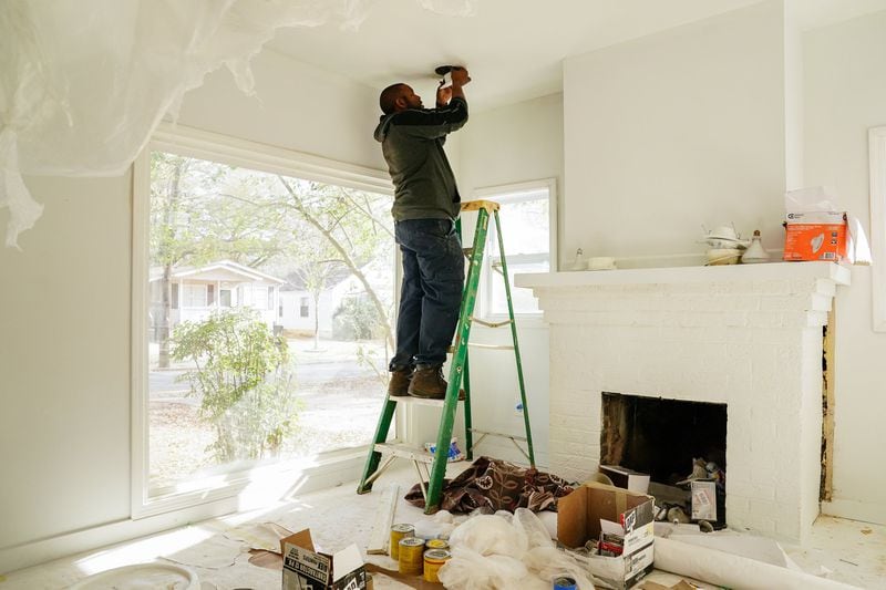 Sherrod Jefferson installs recessed LED lighting on a home he bought to remodel and resell in Atlanta. (Elijah Nouvelage/Special to the Atlanta Journal-Constitution)