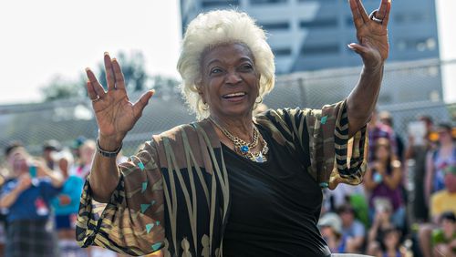 Nichelle Nichols, who played communications officer Lieutenant Uhura aboard the USS Enterprise in the popular Star Trek television series and succeeding motion pictures, gives the Vulcan symbol of live long and prosper as she rides down Peachtree St. during the annual DragonCon Parade in Atlanta on Saturday, September 5, 2015. JONATHAN PHILLIPS / SPECIAL