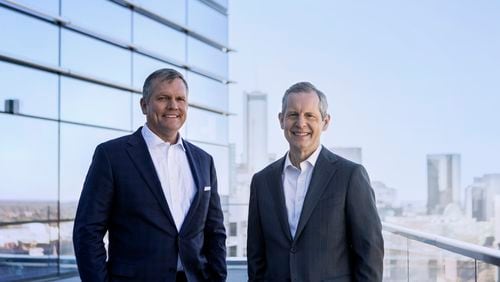 Jim Squires (right) will retire as CEO of Norfolk Southern in May 2022. Alan Shaw (left), chief marketing officer, will succeed him. Squires and Shaw are standing on a balcony at Norfolk Southern's Midtown headquarters.