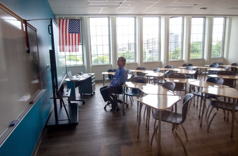  8th-grade teacher Parry Ruder sits in an empty classroom while talking with his students on Zoom on the first day of class at David T. Howard Middle School, Monday, August 25, 2020. STEVE SCHAEFER FOR THE ATLANTA JOURNAL-CONSTITUTION