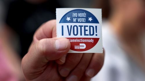 A voter shows off their, 'I Voted", sticker after casting their ballot at a polling station on Nov. 8, 2022, in Miami. (Joe Raedle/Getty Images/TNS)