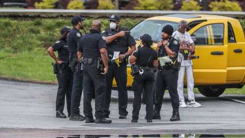 Atlanta police officers investigate a shooting after a gunman tried to steal an armored truck this week. (John Spink / John.Spink@ajc.com)