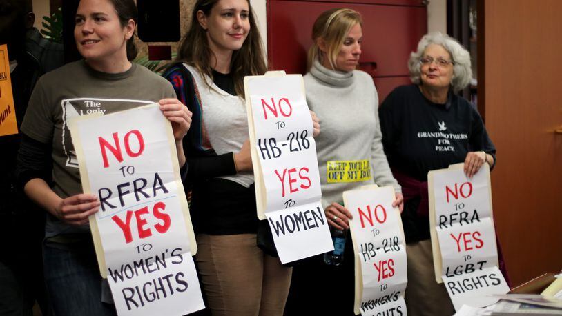 Emma Stitt, from left, Megan Harrison, Jessica Reznicek and Lorraine Fontana stand in Sen. Josh McKoon's, R-Columbus, office in the Coverdell Legislative Office Building in protest of the "religious liberty" bill that McKoon is sponsoring. The four were arrested after they were asked to wait in the hallway, but they refused to leave. The protest was part of Moral Monday Georgia. Ben Gray / bgray@ajc.com