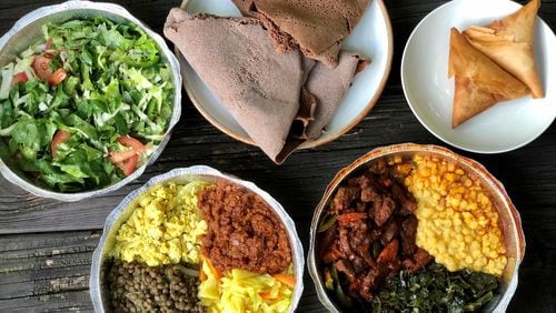A takeout feast from Tigi’s Cafe & Food Truck in Stone Mountain: cabbage salad; teff injera; sambusas; beef tibs with collards and yellow split chickpeas; and a vegan sampler with tofu, split lentils in berbere sauce and brown lentils. CONTRIBUTED BY WENDELL BROCK