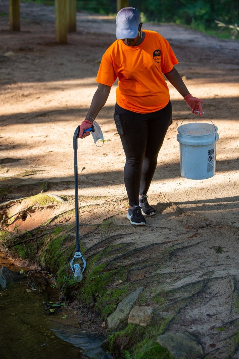 Karen Edwards uses a grabber to pick up a bottle as she works a group of his neighbors picking up trash at Hairston Park in Stone Mountain. PHIL SKINNER FOR THE ATLANTA JOURNAL-CONSTITUTION.