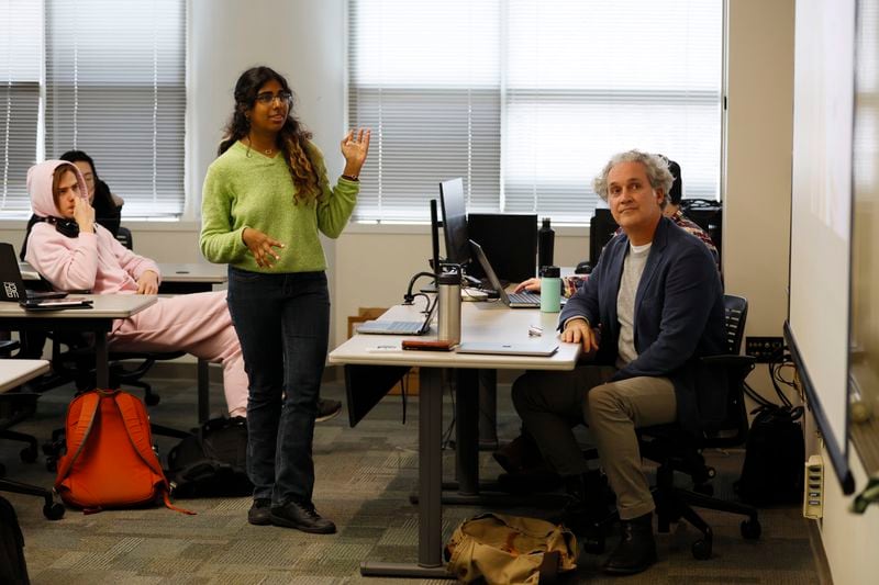 Computer science student Ramya Iyer (center) shows a presentation to professor Mark Leibert (right) during an Art & AI project session at Georgia Tech on Jan. 31, 2022. Miguel Martinez / miguel.martinezjimenez@ajc.com