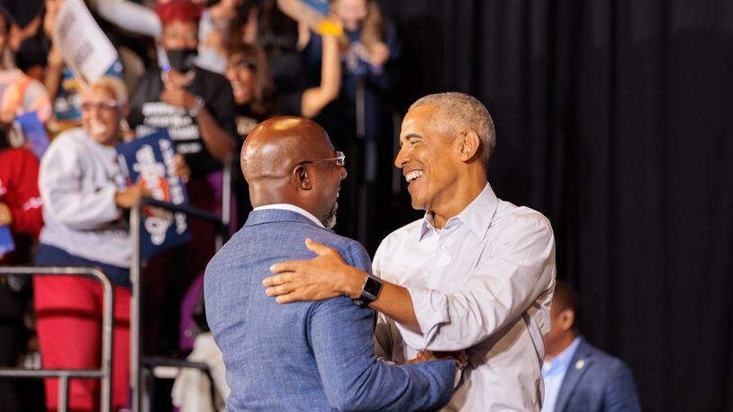 Former President Barack Obama, right, embraces U.S. Sen. Raphael Warnock during a metro Atlanta campaign event for Democrats in October. Obama will return to the area on Dec. 1 to give a boost to Warnock's campaign in the Dec. 6 runoff.  (Arvin Temkar / arvin.temkar@ajc.com)