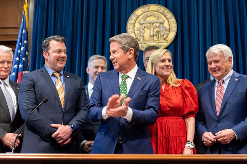 Last month, Gov. Brian Kemp (center) signed a bill into law that allows a  commission to discipline and remove prosecutors.