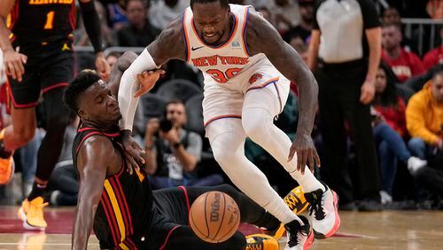 Atlanta Hawks center Clint Capela (15) and New York Knicks forward Julius Randle (30) both dive for the ball in the first half of an NBA basketball game, Wednesday, Nov. 15, 2023, in Atlanta. (AP Photo/Brynn Anderson)
