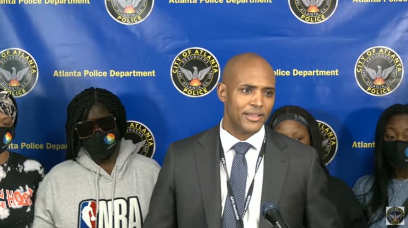 Atlanta police Lt. Ralph Woolfolk, commander of the department's homicide unit, stands with family members of 23-year-old Darrien Giles, who was shot and killed March 7 in southeast Atlanta.