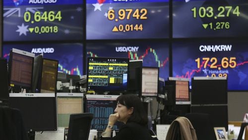 A currency trader watches monitors at the foreign exchange dealing room of the KEB Hana Bank headquarters in Seoul, South Korea, Thursday, March 12, 2020. Asian shares plunged Thursday after the World Health Organization declared a coronavirus pandemic and indexes sank deeply on Wall Street. (AP Photo/Ahn Young-joon)
