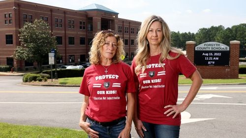 081522 Cumming, Ga.: Alison Hair, left, and Cindy Martin stand in front of the Forsyth County Schools building Monday, August 15, 2022, in Cumming, Ga. Hair and Martin are plaintiffs in a federal lawsuit that contends their constitutional free speech rights were violated when the Forsyth school board refused to allow them to read aloud from school library books during public meetings. Hair and Martin wore shirts that read, “Protect Our Kids! Education Not Indoctrination.” (Jason Getz / Jason.Getz@ajc.com)