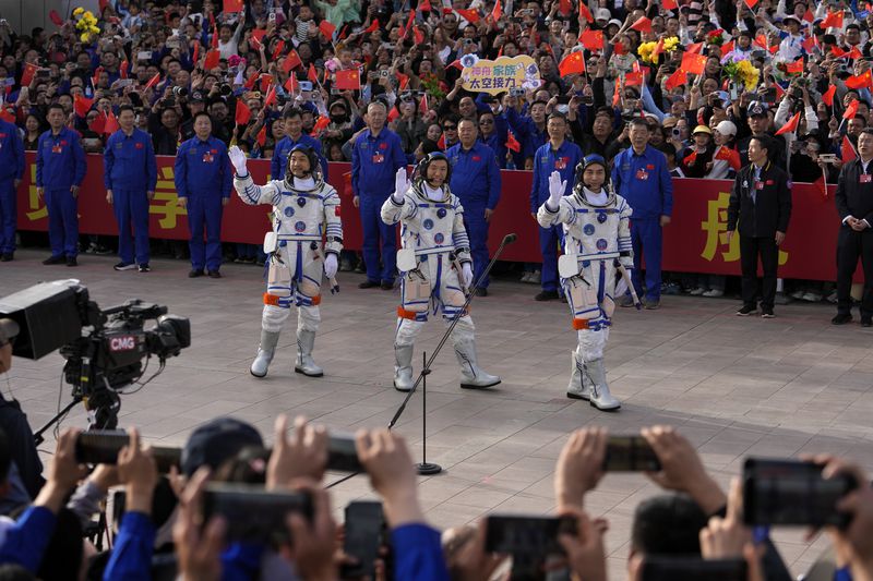 Chinese astronauts for the Shenzhou-18 mission, from left, Li Guangsu, Li Cong and Ye Guangfu wave to spectators as they attend a send-off ceremony for their manned space mission at the Jiuquan Satellite Launch Center in northwestern China, Thursday, April 25, 2024. (AP Photo/Andy Wong)