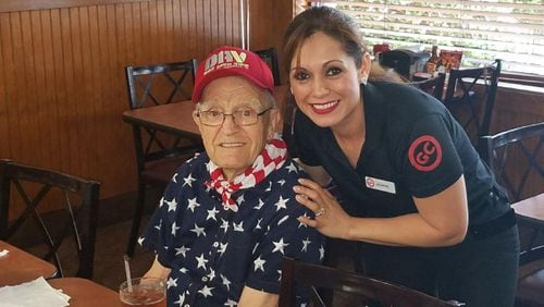 Francis Turner, a World War II veteran, poses for a snapshot with an employee at Golden Corral recently. Restaurant staff honored Turner with a surprise birthday party and announced plans to help him raise $9,600 to help send children of wounded veterans to Camp Corral. CONTRIBUTED