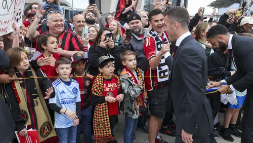 Atlanta United defender Brooks Lennon, right, greets fans as the team arrives before their MLS home opener against the New England Revolution at Mercedes-Benz Stadium, Saturday, March 9, 2024, in Atlanta. (Jason Getz / jason.getz@ajc.com)