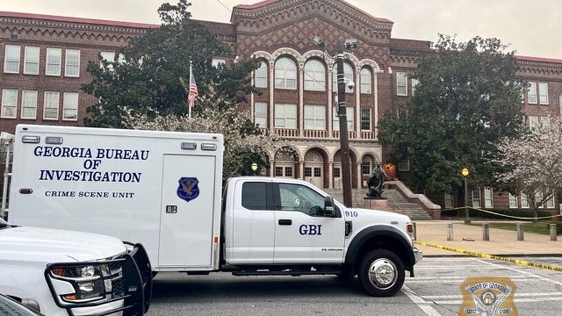 A GBI vehicle is parked in front of Booker T. Washington High School, where an Atlanta Public Schools police officer shot a parent who was allegedly brandishing a gun outside the building Wednesday.