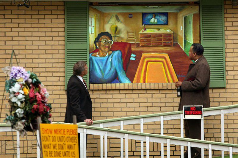 John Gordon, left, and the Rev. Anthony Motley admire a Janssen Robinson mural of Kathryn Johnston painted on plywood over her boarded up home in the English Avenue community in 2008. CURTIS COMPTON / ccompton@ajc.com