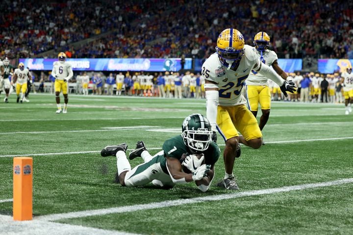 Michigan State Spartans wide receiver Jayden Reed (1) scores a receiving touchdown against Pittsburgh Panthers defensive back A.J. Woods (25) during the first half of the Chick-fil-A Peach Bowl at Mercedes-Benz Stadium in Atlanta, Thursday, December 30, 2021. JASON GETZ FOR THE ATLANTA JOURNAL-CONSTITUTION