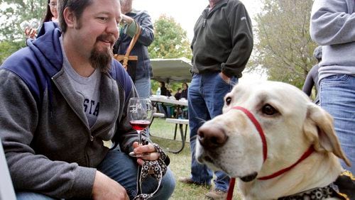 Scott Dible of Fairborn enjoys a sample of wine with his Labrador retreiver Einzig while attending the Dogtoberfest fundraiser for the Clark County Humane Society at Brandeberry Winery on Saturday, October 2, 2010.