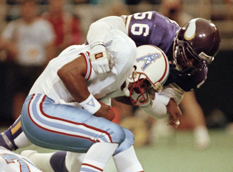 FILE - In this Aug. 27, 1990, file photo, Minnesota Vikings linebacker Chris Doleman (56) brings down Houston Oilers quarterback Warren Moon for a safety during preseason NFL football action in Minneapolis. Hall of Fame defensive end Doleman, who became one of the NFL's most feared pass rushers during 15 seasons in the league, has died. He was 58. The Vikings and Pro Football Hall of Fame president and CEO David Baker offered their condolences in separate statements late Tuesday night, Jan. 29, 2020. (AP Photo/Jim Mone, File)