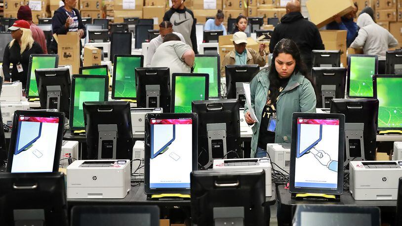 Workers test and pack thousands of the state’s new voting machines Tuesday in a metro Atlanta warehouse. Curtis Compton ccompton@ajc.com