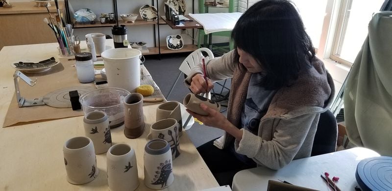 Reiko Miyagi paints hand-thrown decorative ceramics at Tabula Rasa, her studio in the River Arts District in Asheville, North Carolina. 
Courtesy of Tracey Teo