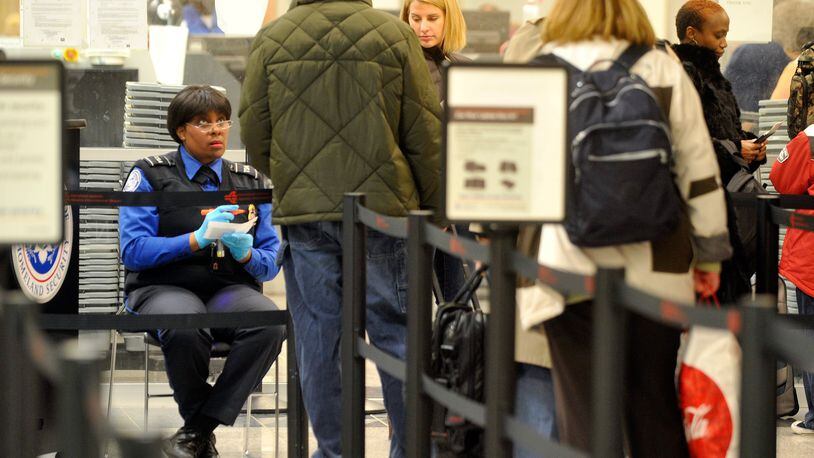 A TSA agent checks IDs and boarding passes of travelers making their way through a security checkpoint at Hartsfield-Jackson Atlanta International Airport in 2010. Credit: Bita Honarvar.