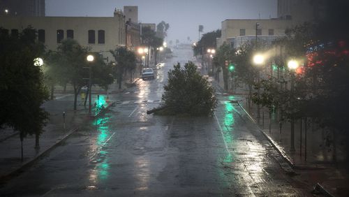 An entire tree blocks a street as Hurricane Harvey makes landfall in Corpus Christi, Texas, on Friday. Several power lines, stop lights and trees were upended and strewn throughout the streets of downtown Corpus Christi as the category 4 hurricane ripped through the Texas coast. NICK WAGNER / AMERICAN-STATESMAN