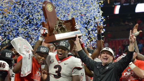 Georgia linebacker Roquan Smith (left), the game’s MVP,  coach Kirby Smart and other Bulldogs players celebrate after a 28-7 win over Auburn in the SEC championship game Saturday at Mercedes-Benz Stadium.