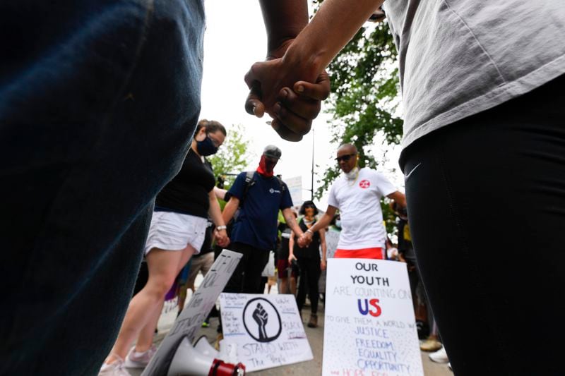 A group gathered in front of the Atlanta Public Safety head quarters prays before during marching through the streets Saturday, June 6, 2020, in Atlanta. Protesters were demonstrating against the death of George Floyd at the knee of Minneapolis police. JOHN AMIS FOR THE ATLANTA JOURNAL-CONSTITUTION